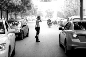 3月31日，天伦东路，一男子穿着破烂不堪的短裤、一双破旧的皮鞋，光着上身在路边跳舞，指挥交通。本报记者陈杰摄影报道 