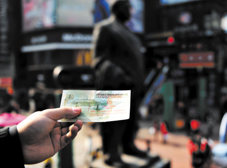 这张一元人民币被商家私自印刷促销广告后，变成了不伦不类的代金券。邹麟 摄