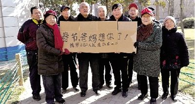 10位老人举起一张纸板，上面写着：春节，爸妈想你了！