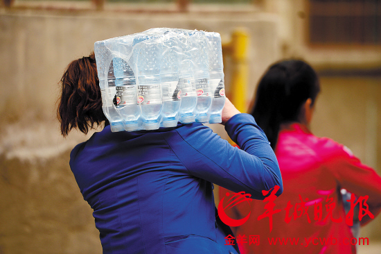 　　兰州两位居民扛着购买的纯净水回家 　　新华社发