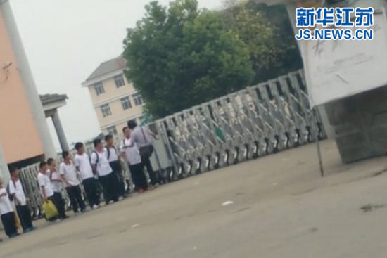 视频截图显示,一名男性工作人员正在脚踹学生。