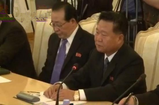 崔龙海胸口佩戴金正日与金正恩画像的红旗徽章