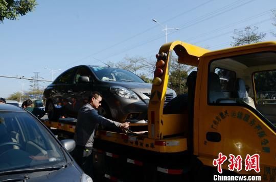 14日上午8时许，广州发生道路塌陷，惊现5米多深的“天坑”，车身大半截悬空的小车被安全吊离。　朱嘉玮　摄