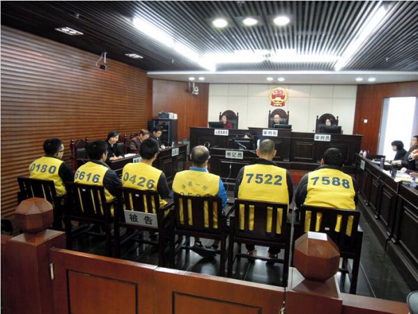 身着黄色背心，坐在被告席的日本人(自左起5人)，最右为共犯台湾人被告。