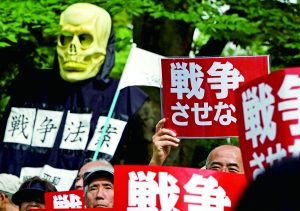 6月14日，在日本东京，抗议者手持标语参加抗议安保法案的游行。新华/法新