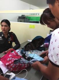 8月13日下午，芭提雅警察局，办案警官将张春蓉遗物交给其父母。 图/记者王欢