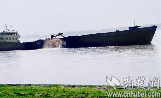 前日上午11时左右，在西向湾码头工作的村民拍到货船用铲车向江中倾倒渣土的画面。 读者供图