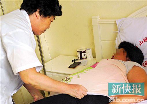 ▲采访过程中,医院产科主任为阿娥翻身。
