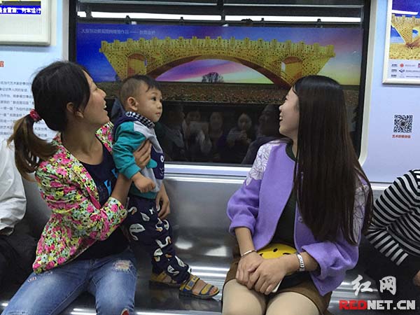 车厢内的小孩子对作品好奇，忍不住站起来看看。