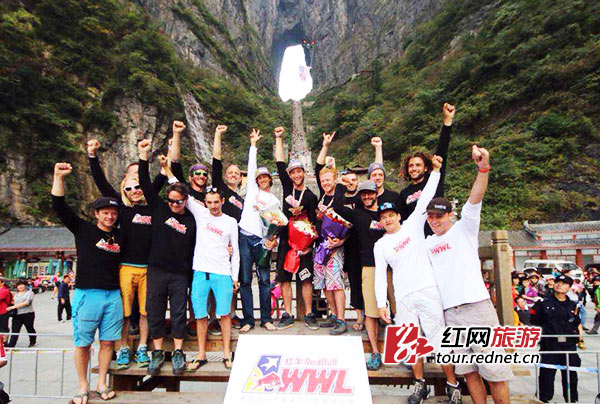 美国选手诺亚 [中] 加冕新科“翼装之王”。颁奖后，大家一起站上颁奖台，大喊“天门山，不见不散！”