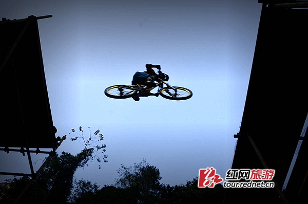 自行车速降爱好者在张家界武陵源黄石寨景区体验极限速降。