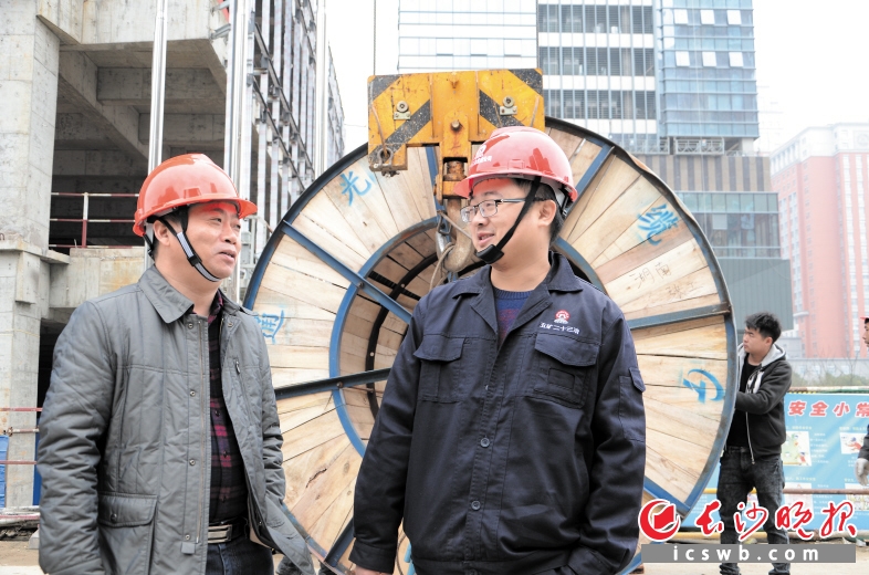 为解决农民工参保工伤保险的问题，陈贵平（左）数十次走进长沙建筑工地调研。长沙晚报通讯员 李航 摄