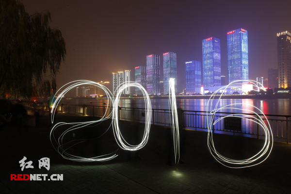 跨年夜，长沙市民在湘江边用手机光影造“2016”，迎接新年到来。杨杨摄