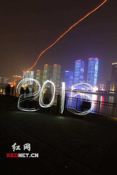 跨年夜，长沙市民在湘江边用手机光影造“2016”，迎接新年到来。杨杨摄