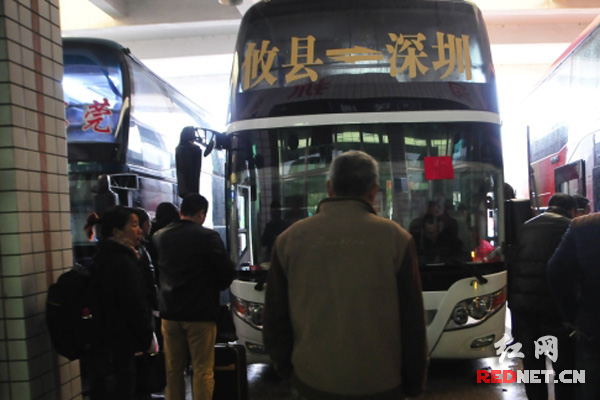 攸县前往深圳的客车周围围满了旅客。