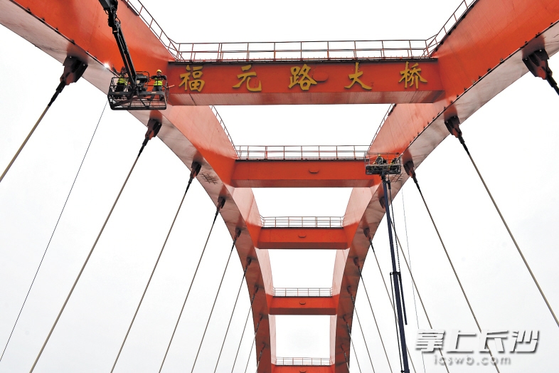 昨日，在福元路大桥上，工人们正在对桥拱内侧加装点光源，改造后的大桥将更加通明透亮。长沙晚报记者 王志伟 摄