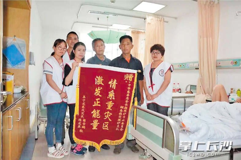 伤者家属给杨玲（右一）等志愿者赠送锦旗表示感谢。