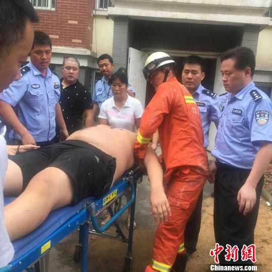 消防队员及民警将150公斤的“胖男”抬下楼。 警方供图 摄