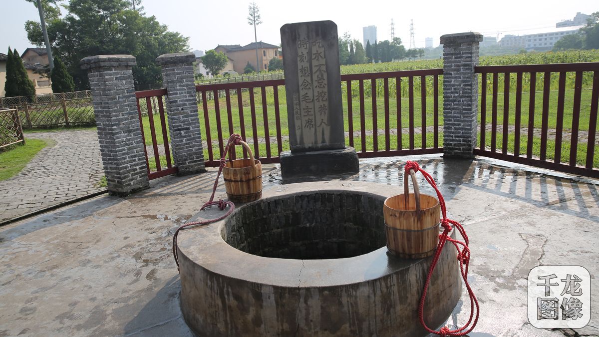 在红井前面，“吃水不忘挖井人 永远不忘毛主席”几个大字镌刻在石碑上。
