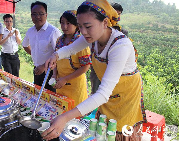 村民邀请大家品尝菖蒲塘村蜜柚做成的蜂蜜柚子茶
