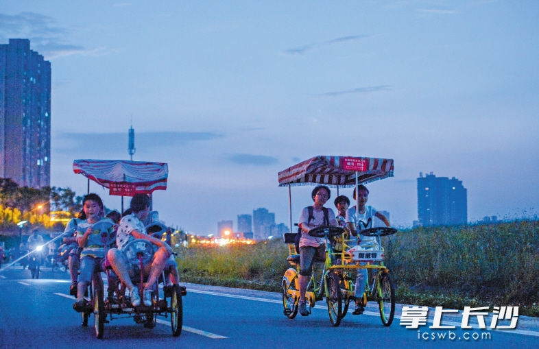  松雅湖畔是市民夜晚骑行纳凉的好去处。 长沙晚报记者 邹麟 摄