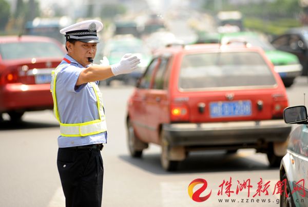 烈日炎炎，交警正在马路上指挥交通。记者 汪成 摄 （资料图）