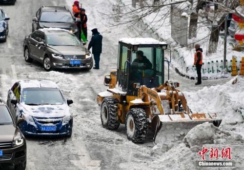 在乌鲁木齐市区，大型机械设备出动清理道路上的积雪。 中新社记者 刘新 摄
