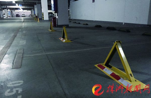 天元区某小区内，地下停车场内没有卖出去的车位被物业公司安装上了地锁  记者 张媛 摄