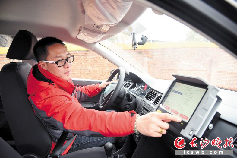 一名教练员在演示如何操作驾培机器人。