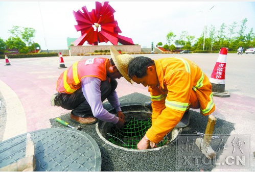 市政工人正在安装防坠网，防止下水道“坑”人。（记者 罗韬 摄）