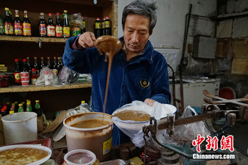 王老板在给顾客舀酱。<a target='_blank' href='http://www.chinanews.com/' >中新网</a>记者 李卿 摄