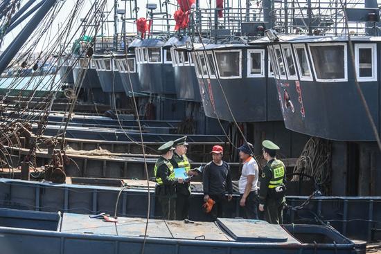 5月1日，大连边防支队桃园边防派出所民警在大连市金州区杏树国家级中心渔港内对回港的渔船进行登记。