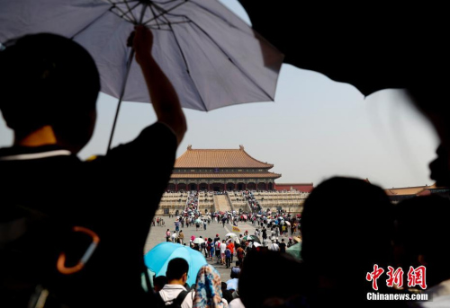 5月18日，游客在北京故宫博物院参观，北京持续高温。中新社记者 杜洋 摄