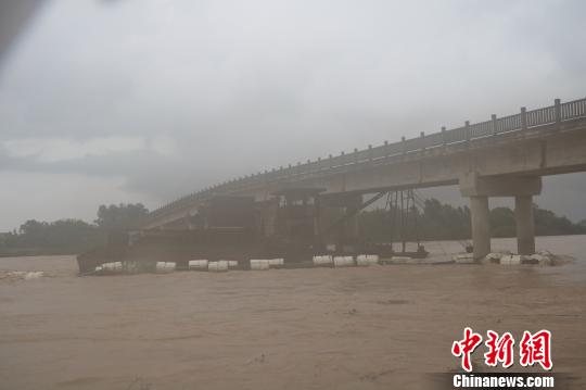 图为抽沙船卡在桥底。 庞健港 摄