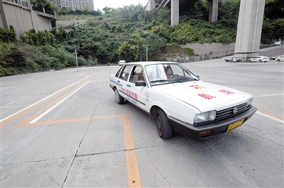 18日，江北区一驾校教练在指导学员进行侧方位停车的练习。本报记者 胡杰 摄