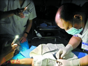 由于停电，医生用手机照明为伤者缝合伤口。广州日报全媒体记者陈治家 通讯员李建束、陈翀摄