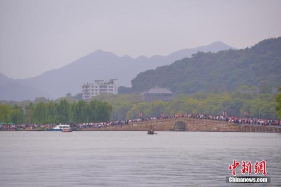 10月3日，国庆长假第三天，参观西湖断桥的游客络绎不绝。 中新社记者 李晨韵 摄