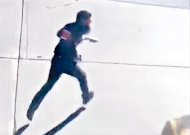  资料图：枪手持假枪横过街道一刻。