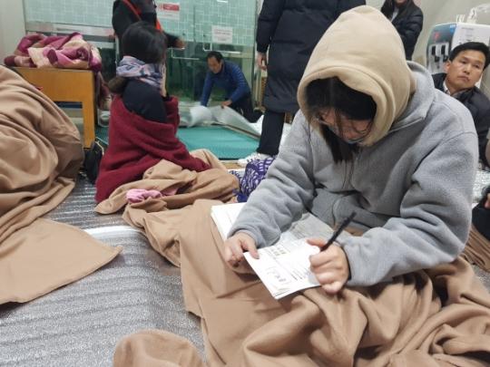  15日，韩国高考生在避难场所熬夜复习