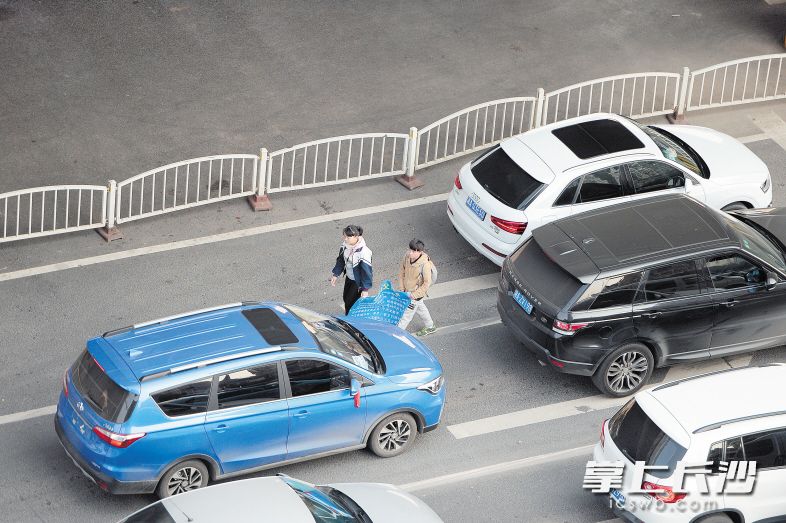 昨日下午，两名少年拿着一张“求助海报”，在东二环某路段向过往司机求助。长沙晚报记者 余劭劼 摄