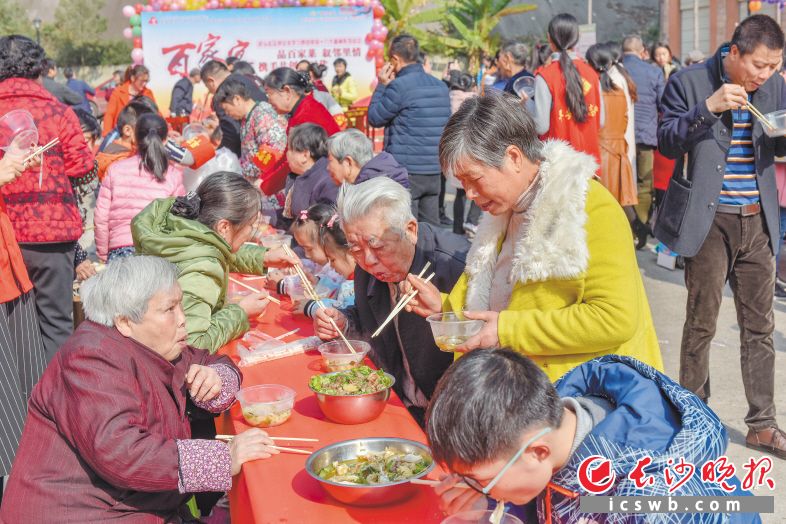 69道家常菜摆上长条桌，天心区新开铺街道桥头社区居民围坐在一起，边拉家常边品尝美食。昨日，以“品百家菜，叙邻里情，携手共创新时代”为主题，桥头社区学习贯彻党的十九大精神系列活动开展。长沙晚报记者 陈飞 摄