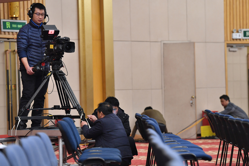 2月27日，工作人员在全国两会新闻中心的新闻发布厅内调试转播设备。