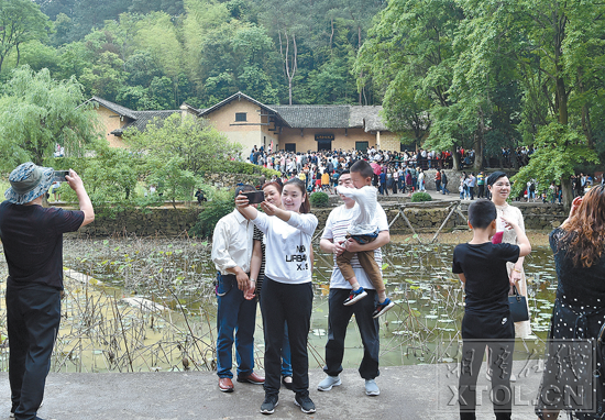 4月29日，游客争相在毛泽东同志故居前拍照留念。 （记者 刘建强 摄）