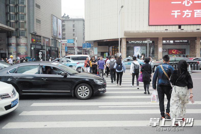 昨日中午，许多行人经黄兴路春天百货路段的斑马线过街，部分车辆未进行礼让。 长沙晚报记者 余劭劼 摄