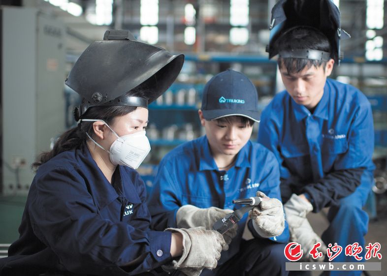 赵小燕（左一）手把手地教学员如何掌握焊接技巧。 长沙晚报记者 黄启晴 摄