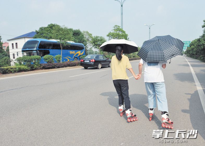 ↑雷锋大道上，一群年轻人溜旱冰竞相追逐。 