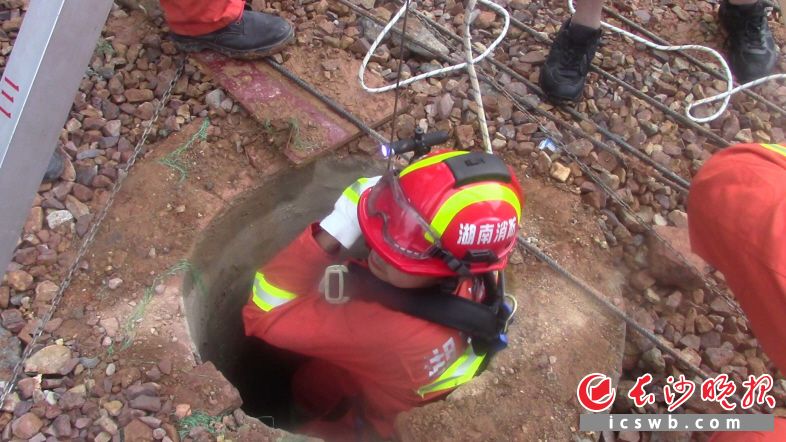 消防战士下井，对被困者展开救援。视频截图