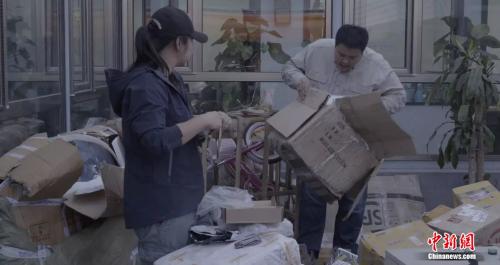 张昕宇和梁红正在收拾满院子的金属。受访者供图