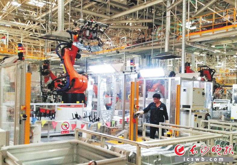 ↑创新驱动，高质量发展。上海大众长沙分公司厂房内，机器人快速作业，工人进行监控，人机协作“智造”汽车。