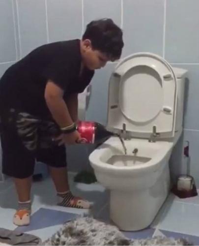 土耳其男孩把可乐倒入马桶。(图:Getty)